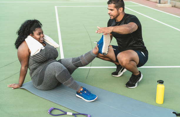 istock Personal trainer working with curvy woman explaining her the exercises routine - Sporty people lifestyle concept 1328141619