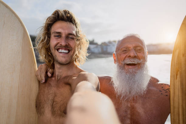 istock Happy fit surfers taking selfie while having fun surfing together at sunset time - Extreme sport lifestyle and friendship concept 1328142508