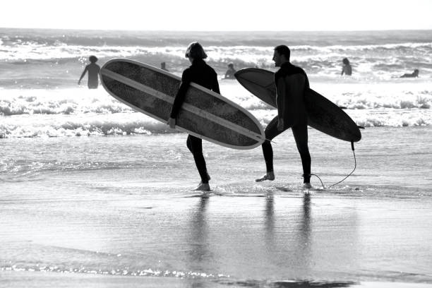 Llangennith, Gower Peninsula, Swansea, Wales. With campsites and beach car parks open surfers flock to the beaches to surf the waves and enjoy the outdoor spaces offered on this beautiful coastline. Enough space for social distancing.