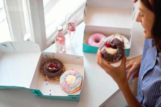 istock Cheerful woman eating delicious donuts 1328149498