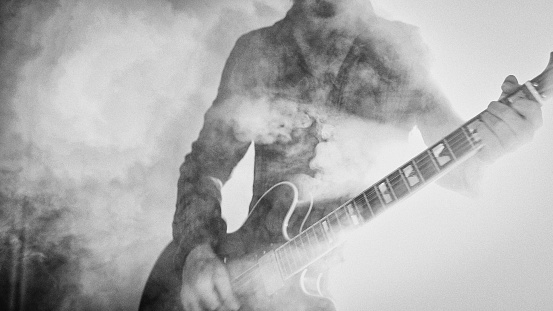 Guitarrista de rock tocando la guitarra en un show en vivo con luces de escenario photo
