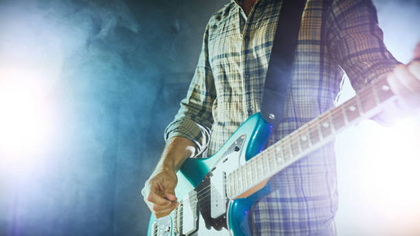 istock Rock guitarist playing guitar in a live show with stage lights 1328150623