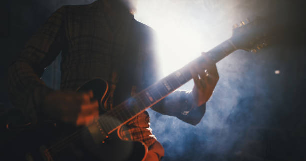 istock Rock guitarist playing guitar in a live show with stage lights 1328150655