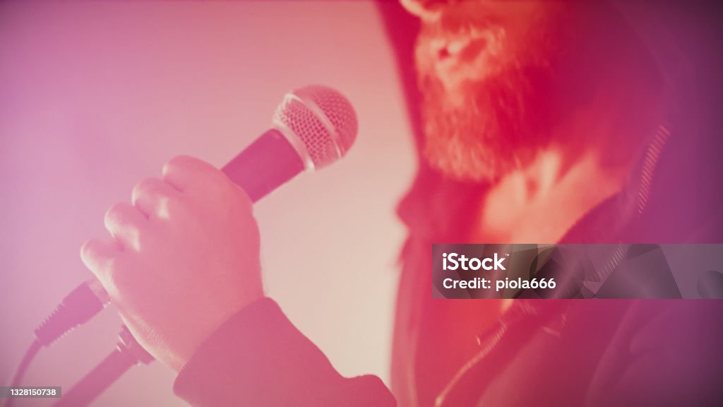 Rock singer screaming in a live show with stage lights Microphone Stock Photo
