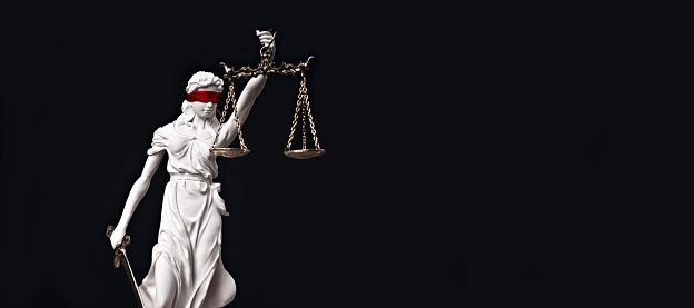 Justitia, the Roman goddess of Justice with red blindfold. Panoramic image with copy space.