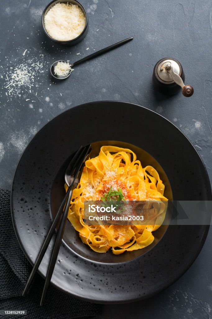 Fettuccine pasta with traditional Italian passat sauce and parmesan cheese in light plate on old white concrete background. Top view. Tagliatelle Stock Photo