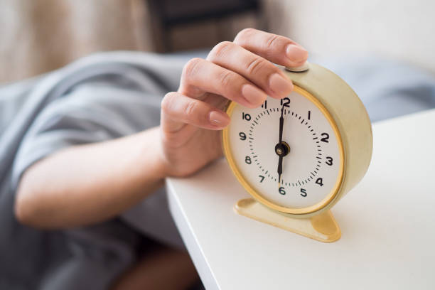 A woman's hand presses the alarm button in the morning. Young woman reach out one's hand Press the button to turn off the alarm clock in morning Young woman reach out one's hand Press the button to turn off the alarm clock in morning. A woman's hand presses the alarm button in the morning. alarm clock stock pictures, royalty-free photos & images