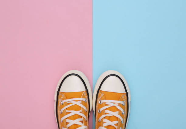 istock Retro sneakers (gumshoes) on pink blue background. Top view. Minimalism 1328156270