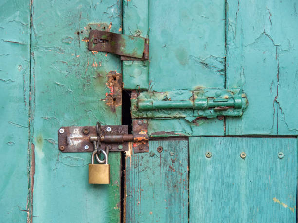 istock Vintage security, ancient bolts and a padlock close this old door. 1328157848