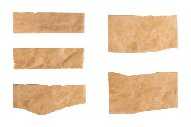 Close up of a ripped piece set of brown paper on white background Close up of a ripped piece set of brown paper on white background torn brown paper stock pictures, royalty-free photos & images