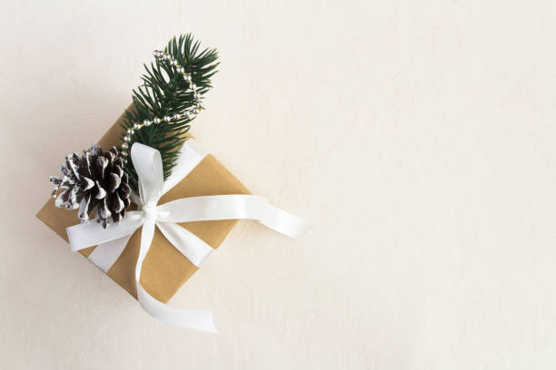 istock Christmas gift box  with tied white bow on the beige textile background 1328165921