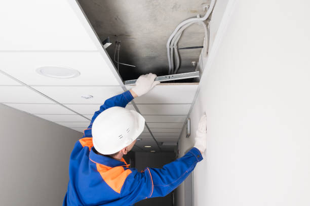 istock a worker in a helmet finishes the installation of a false ceiling, rear view 1328166049