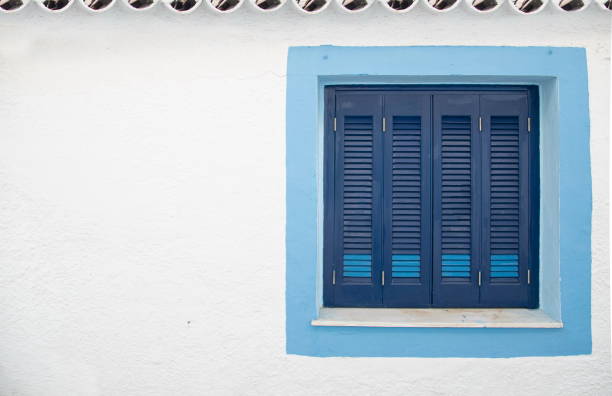 Beautifully painted blue window on a white wall, Spetses Island, Greece