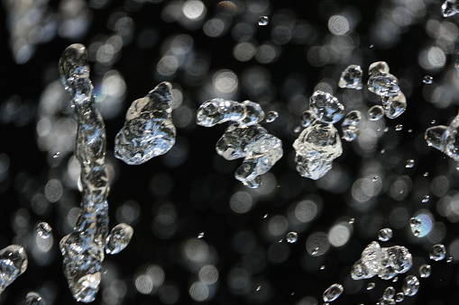 water droplets are stationary (frozen). They come from a public water fountain in France.