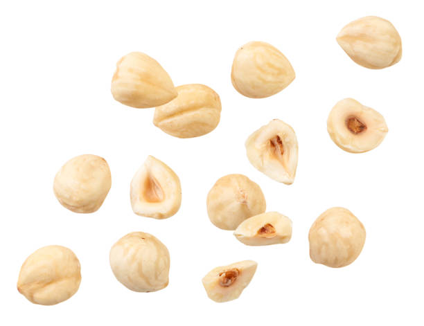 Peeled hazelnuts fly on a white background, levitating hazelnuts. Isolated Peeled hazelnuts fly close-up on a white background, levitating hazelnuts. Isolated levitation stock pictures, royalty-free photos & images