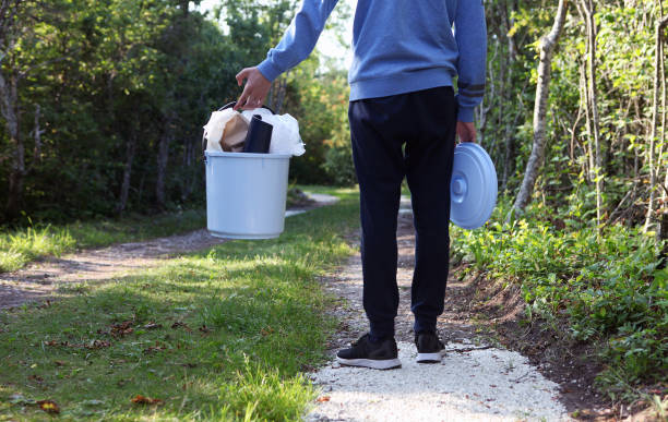 istock Youngster is holding Plastic bucket on the forest path for plastic bottles and trash. 1328175362
