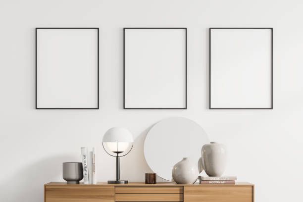 istock Minimalistic white living room interior with bookshelf and three vertical posters 1328176940