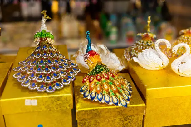 Variety of original multicolored minifigures jeweled with sparkling crystals on shelves of Georgian souvenir shop