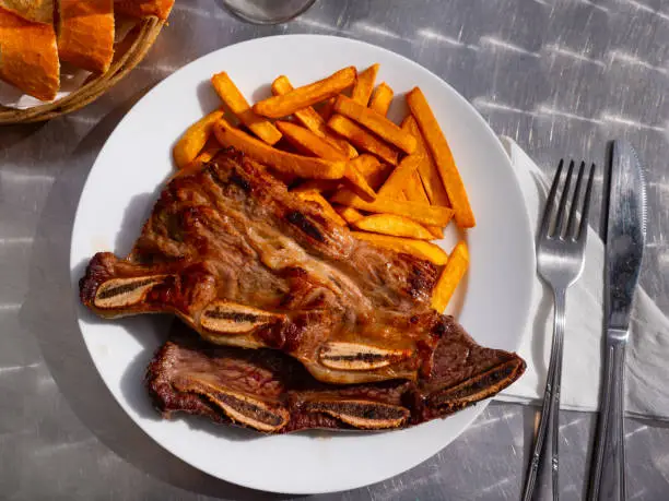 Photo of Grilled beef ribs with vegetable garnish of french fries