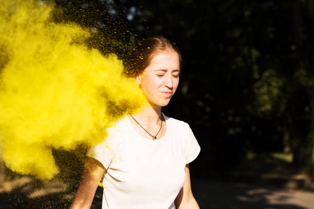 istock Pretty young woman in vibrant colors exploding around her at Holi celebration 1328183336