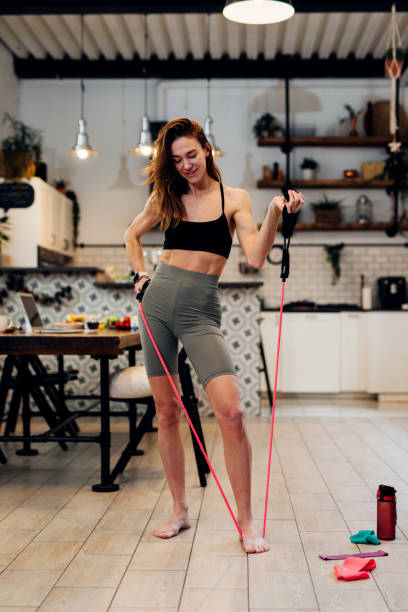istock Woman works out at home Resistance band biceps curl 1328189143