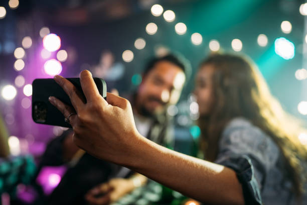 Crowd people in nightclub. Asian couple celebrating at party after working. friends in bar with phones stock pictures, royalty-free photos & images