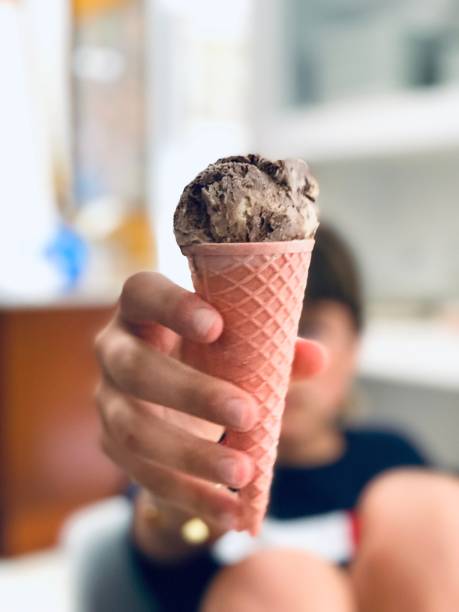 istock Girl holding an ice cream cone 1328191177