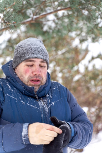 istock frozen Caucasian man with snow on eyelashes puts on gloves 1328192251