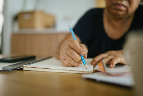 istock Asian woman calculating expenses. 1328192838
