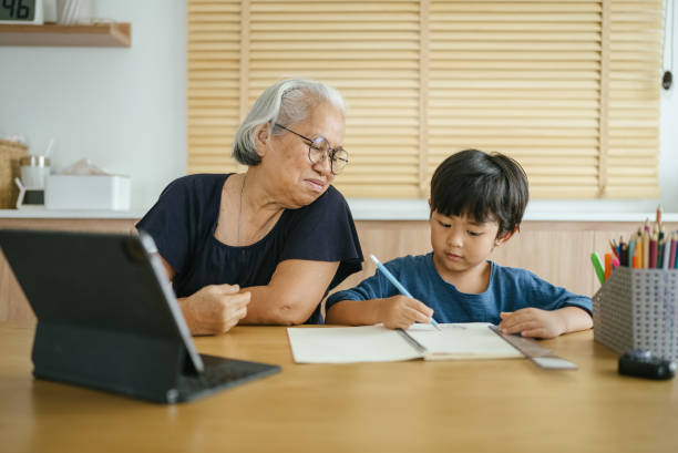 istock Grandmother helping grandson do homework. 1328192929