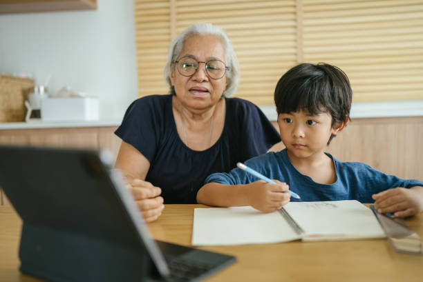 istock Grandmother helping grandson do homework. 1328193505