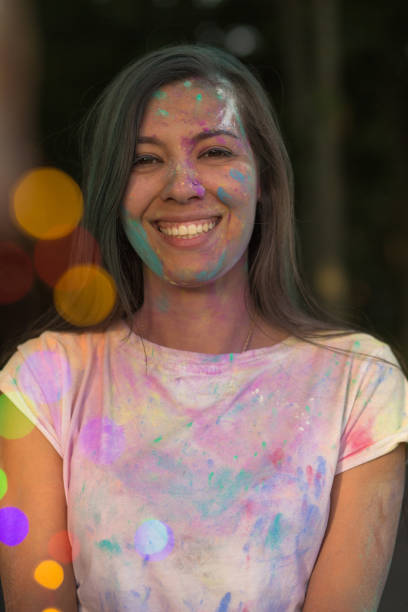 istock Cheerful young asian model having fun with Holi paint posing with bokeh from garland 1328198576