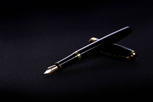 istock Black fountain pen on a black plastic desk 1328200367