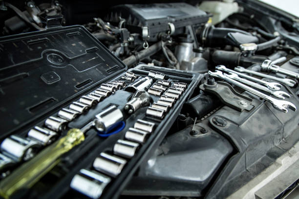 istock Car mechanic man at the garage fixing the engine 1328201718