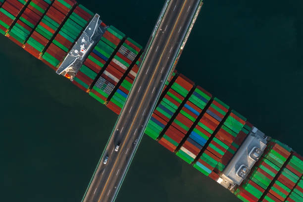 istock Cargo Vessel traveling under a suspension bridge close up. 1328202117