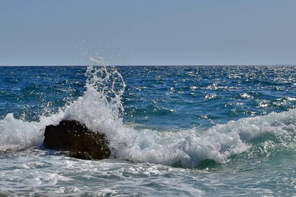istock Splashing of waves crashing on stones 1328204757