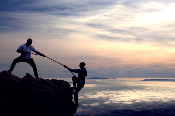 Teamwork on mountain peak Teamwork on mountain peak climbing up a hill stock pictures, royalty-free photos & images