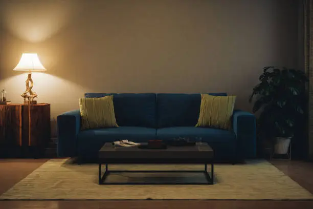 Living room with modern furniture, illuminated by table lamp.