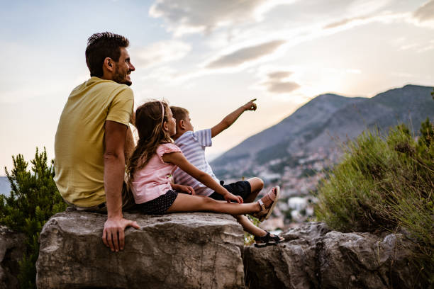 istock Young family relaxing in mountains at sunset 1328221120