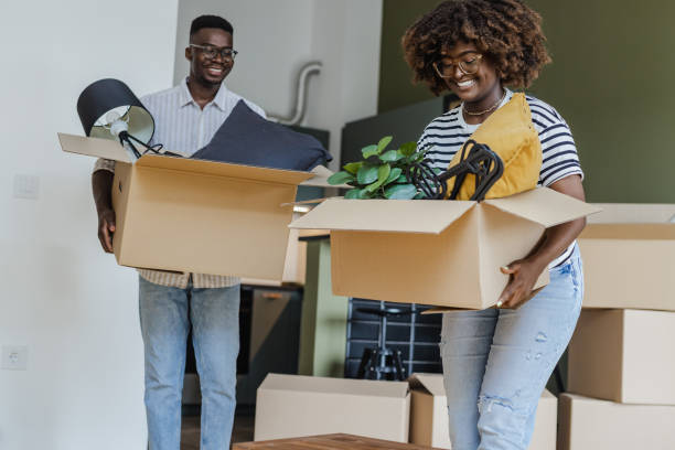 istock Couple carrying boxes into new apartment 1328223143