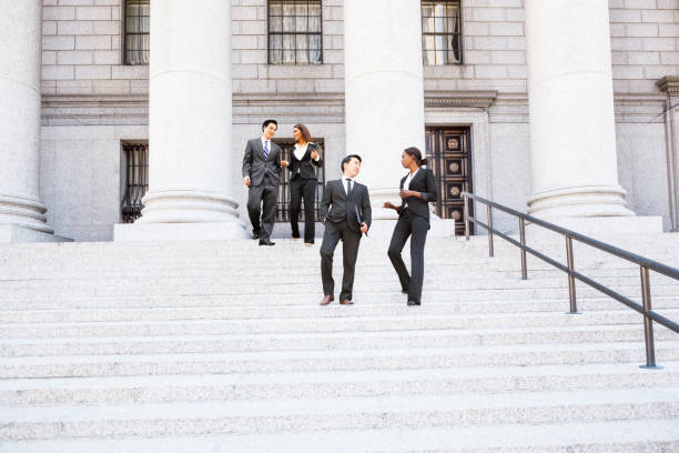 four people walk down courthouse steps - government building imagens e fotografias de stock