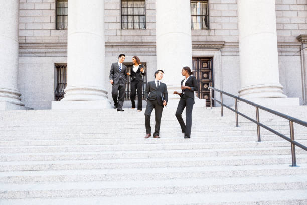 четыре человека спускаются по ступеням здания суда - courthouse staircase politician business стоковые фото и изображения