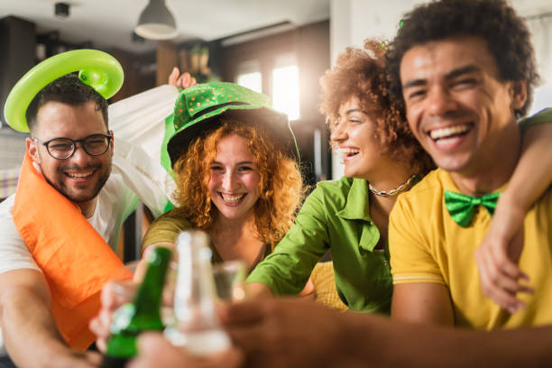 Multiethnic Group Of Young People Having Fun And Drinking Beer Together. Ireland national symbols. St Patricks Day. Multiethnic Group Of Young People Having Fun And Drinking Beer Together. Ireland national symbols. St Patrick Day. st. patricks day stock pictures, royalty-free photos & images