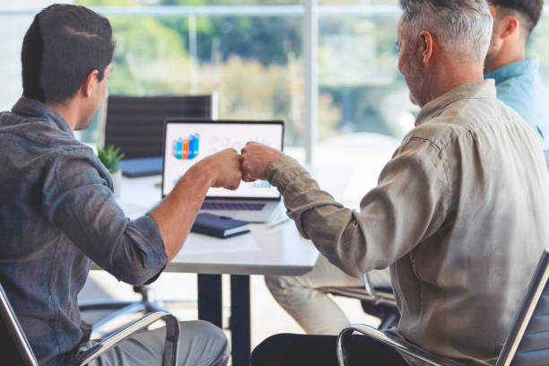 istock two businessmen fist bumping. 1328226436