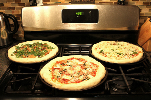 Stovetop pizzas on skillets.