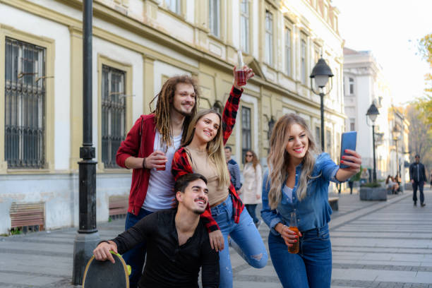 istock Attractive Couples are Using a Mobile Phone to Take a Selfie While Walking in City Street. 1328234474
