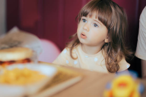 süßes kleines mädchen, das in einem fast-food-restaurant sitzt - eating obsessive child toddler stock-fotos und bilder