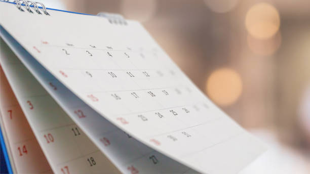 gros plan sur le calendrier du bureau du livre blanc avec un rendez-vous en arrière-plan bokeh flou et un concept de réunion d’affaires - calendar date photos photos et images de collection