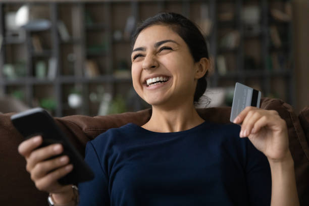 istock Close up overjoyed Indian woman using smartphone, paying online 1328237087