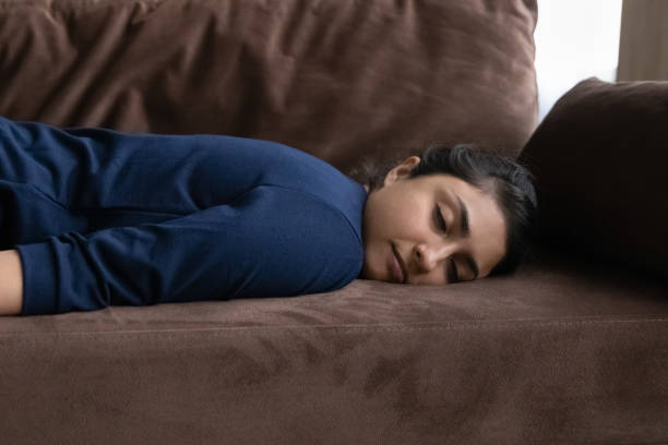 istock Close up exhausted Indian woman falling asleep, lying on couch 1328237112